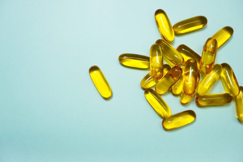multiple yellow vitamins on a blue background