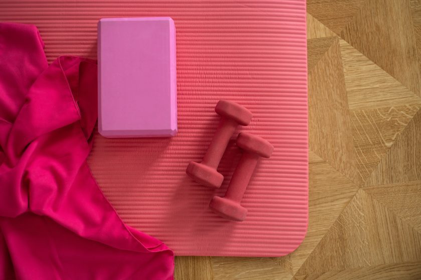 Pink Pilates mat with weights and block.
