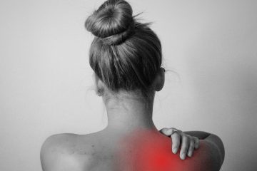 woman holding her shoulder in pain
