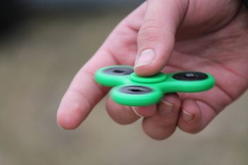 person holding a green fidget spinner